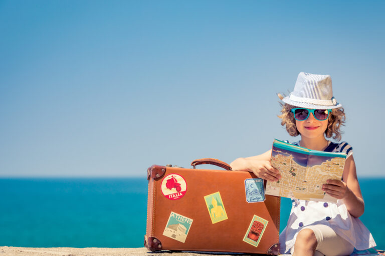 Dziecko z walizką nad morzem