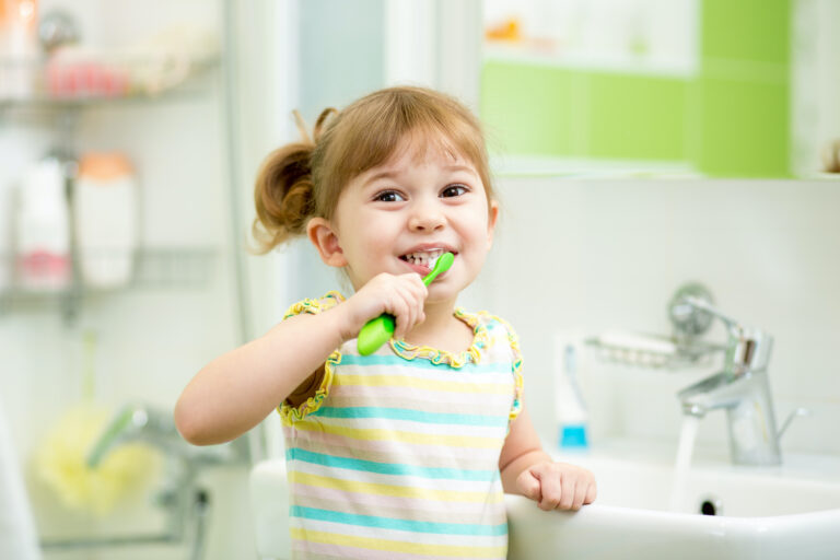 zadowolona dziewczynka myje zęby