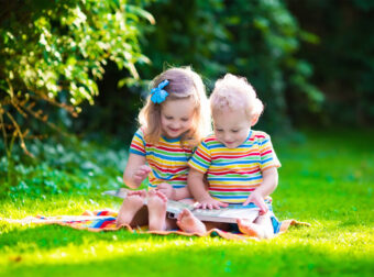 dzieci czytają książki w plenerze