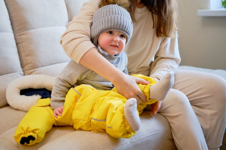 mama ubiera dziecko na spacer zimą w kombinezon