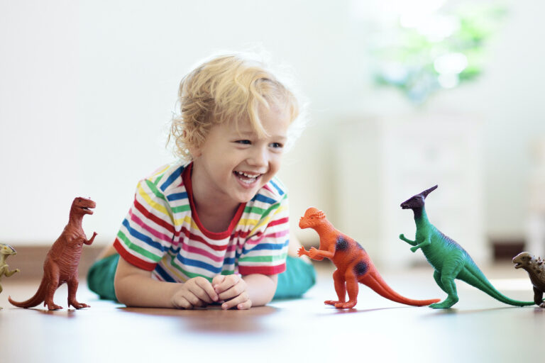 mały chłopczyk bawi się z figurkami dinozaurów